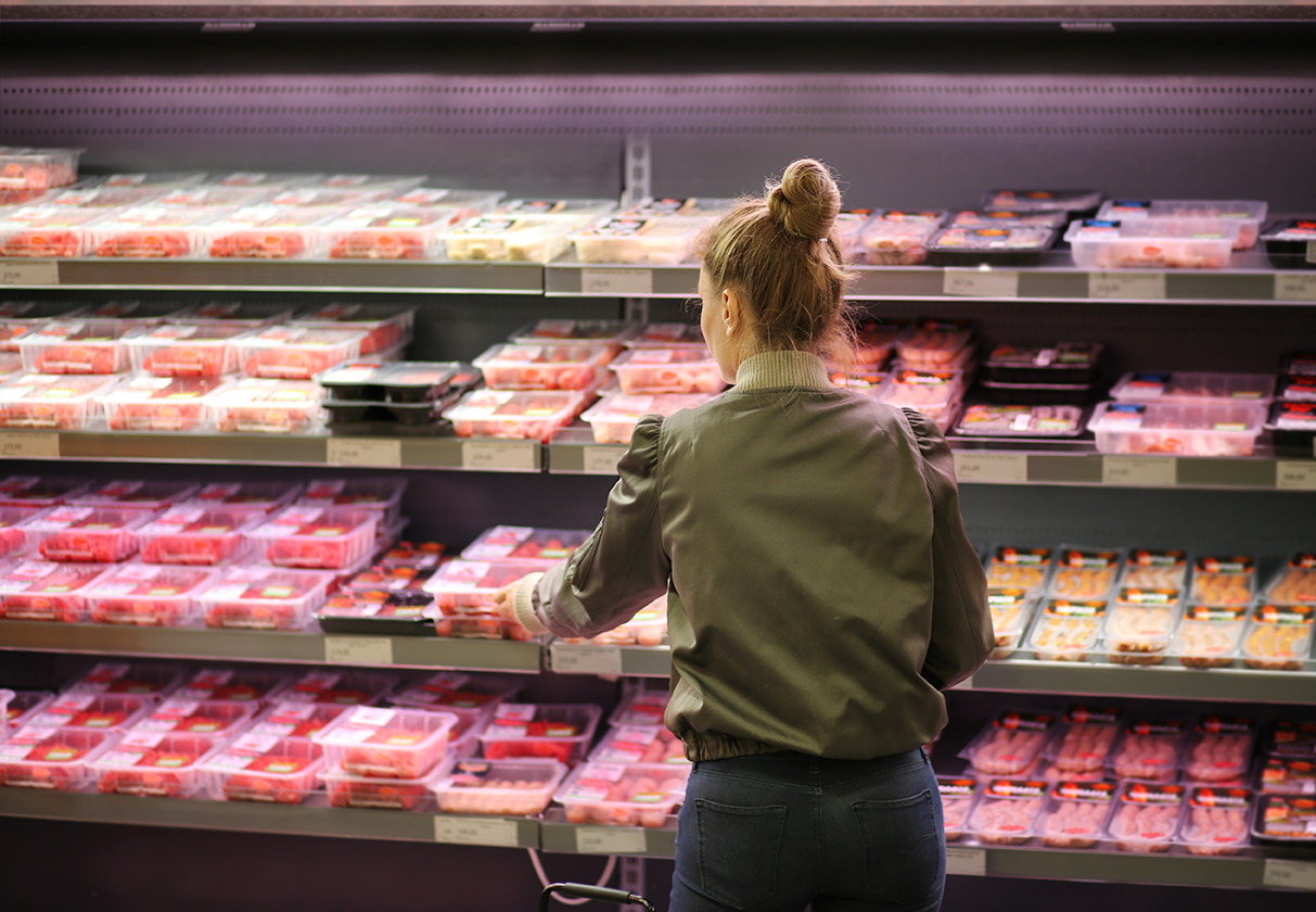 Woman purchasing a packet of meat at the supermarket